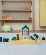A simple construction made from Grimms movement building set on a fluffy rug in a playroom