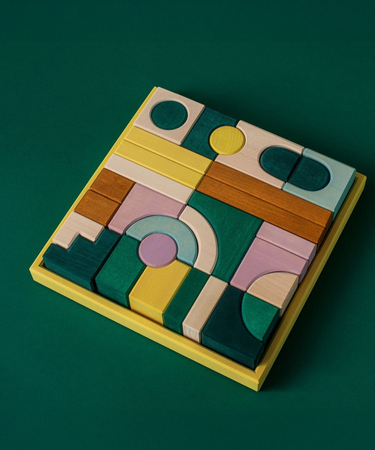 Grimm's wooden movement hand crafted pieces in a yellow square frame against a green background