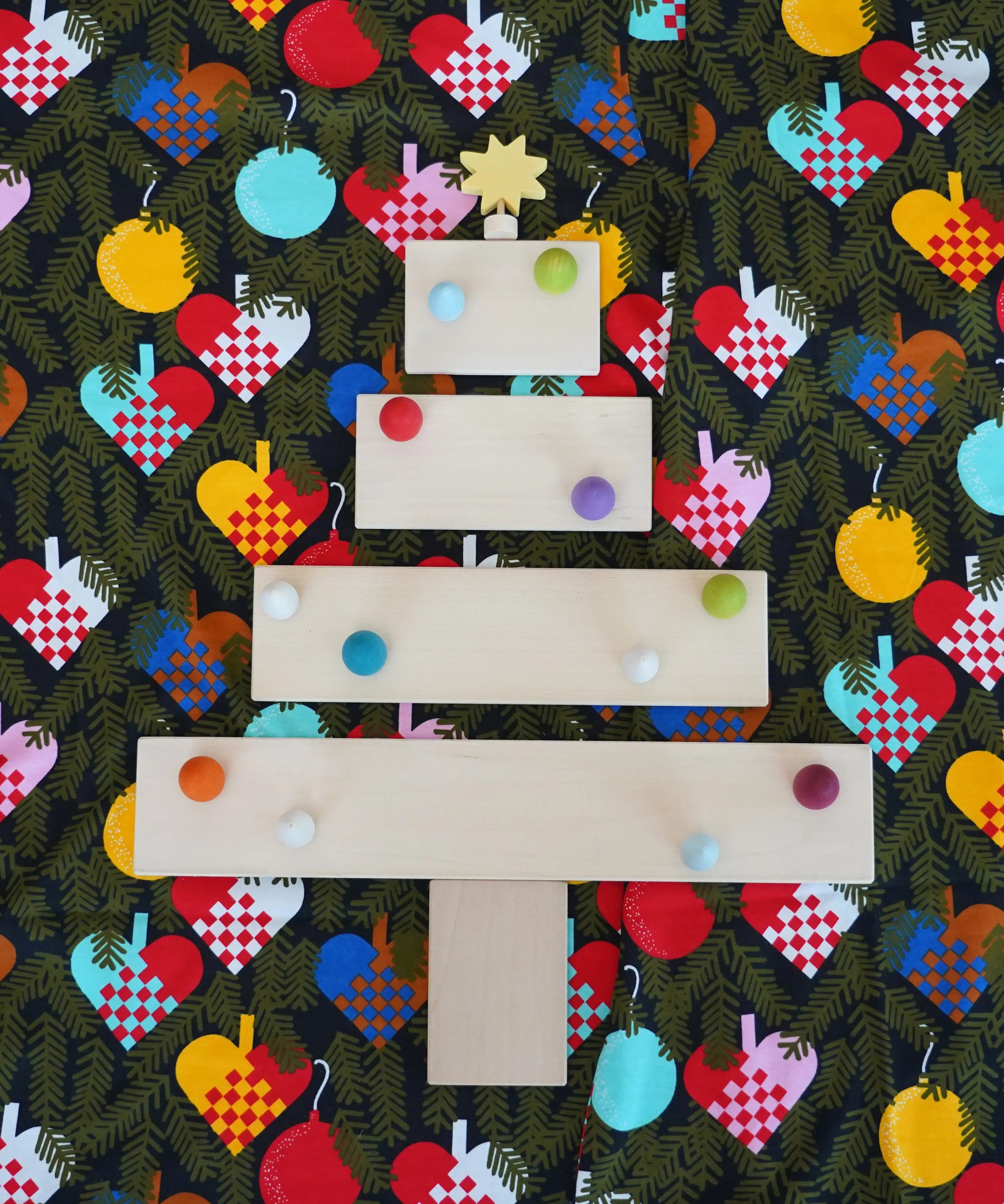 A festive flatlay showing a Christmas tree made from Grimms wooden natural building boards 