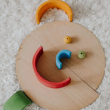 A playful looking face made loose Grimm's natural wooden semi circle pieces and other loose blocks