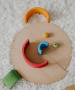 A playful looking face made loose Grimm's natural wooden semi circle pieces and other loose blocks