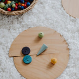 A abstract looking face made loose Grimm's natural wooden semi circle pieces and other loose blocks