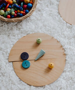 A abstract looking face made loose Grimm's natural wooden semi circle pieces and other loose blocks