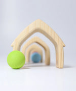 Front of Grimms wooden natural house pieces lined up with a pastel ball in front showing scale