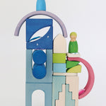 A beautiful play scene of a front of a house using the wooden try as a backdrop and the gems attached to the try like stars. The arch blocks are carefully balanced on top of the tray