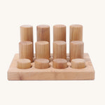 Different sized Grimms natural rollers on a wooden frame on a cream background.