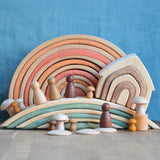 Grimm's handcrafted wooden bridges displayed with a natural rainbow, house, peg dolls and other building blocks