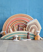 Grimm's handcrafted wooden bridges displayed with a natural rainbow, house, peg dolls and other building blocks