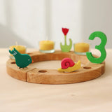 Grimm's handcrafted celebration ring with a pecking bird, pink snail, and a number 3 decorative figure 