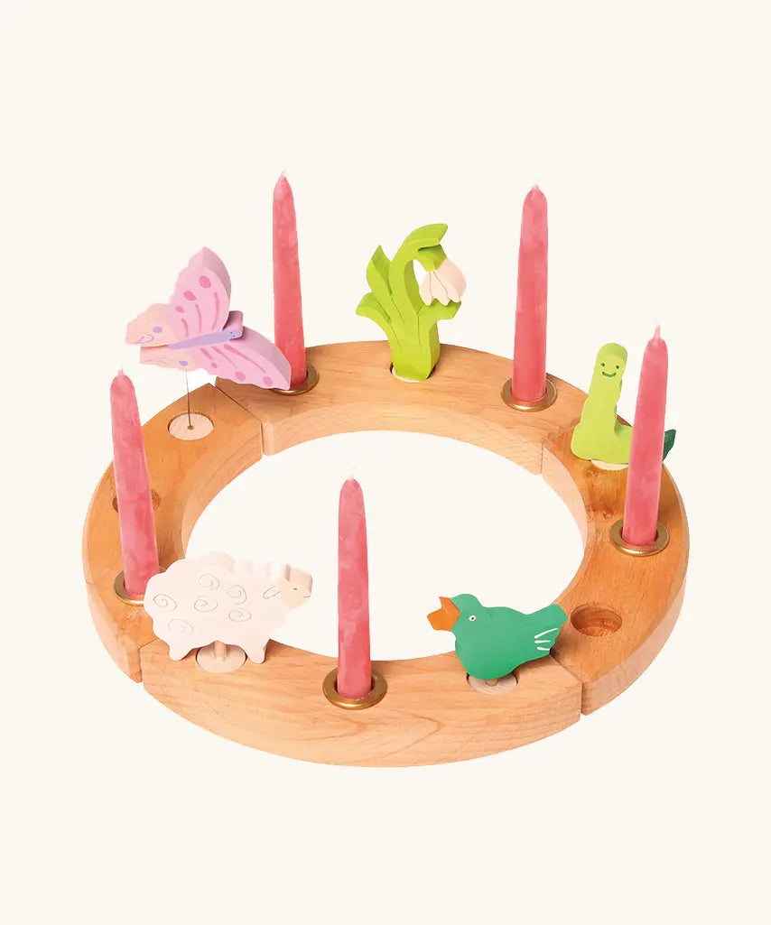 Grimm's handcrafted wooden celebration ring with various decorative figures including a butterfly snowdrop, worm, signing bird and sheep