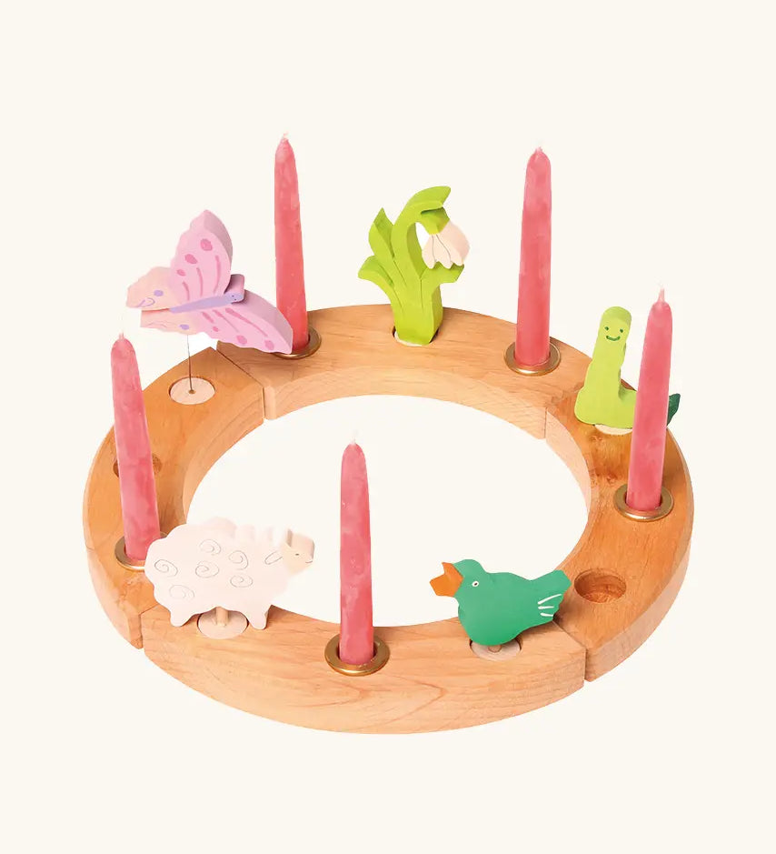 Grimm's handcrafted wooden celebration ring with various decorative figures including a butterfly snowdrop, worm, signing bird and sheep