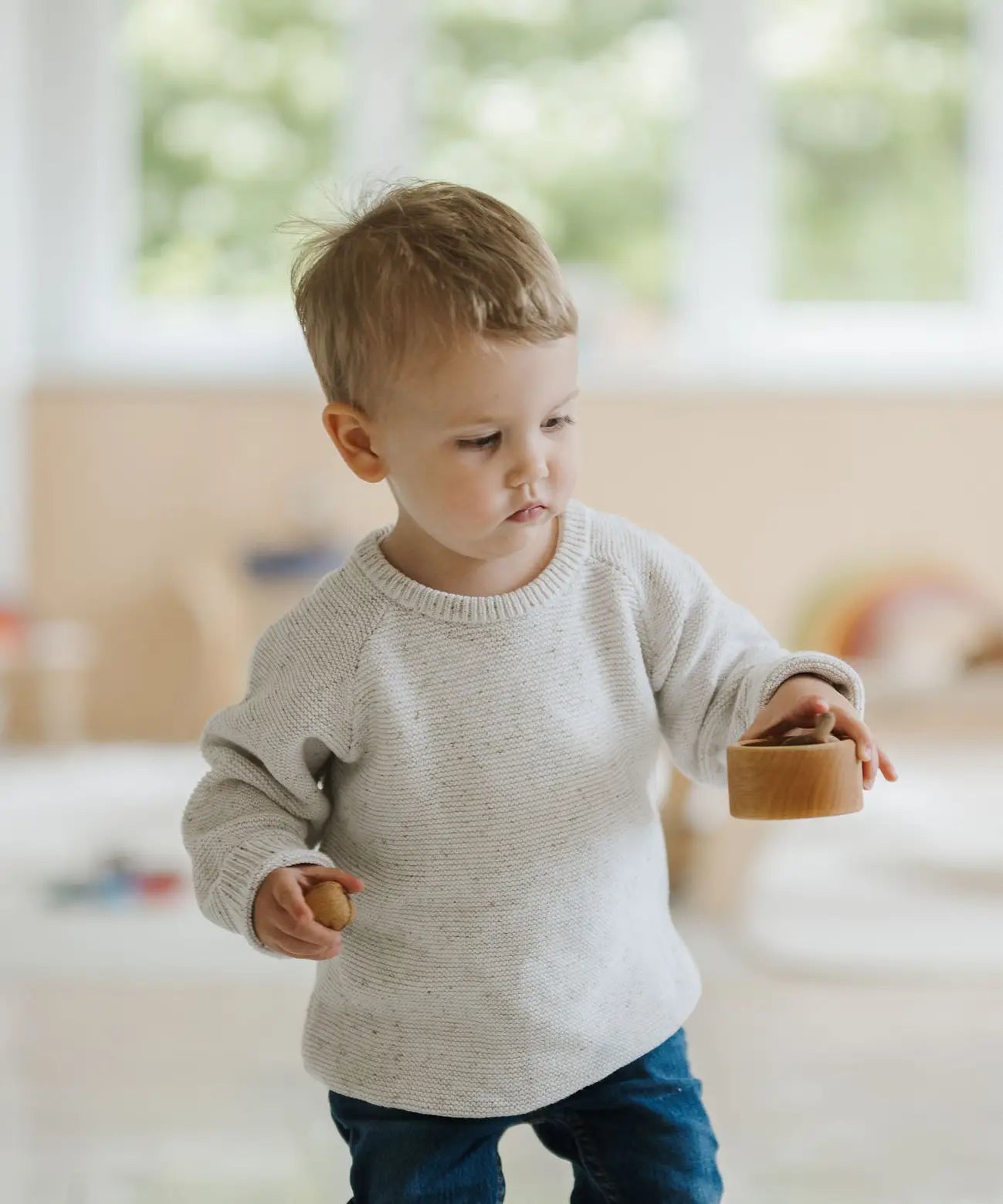 Child holding a medium sized Grimms natural wooden bowl