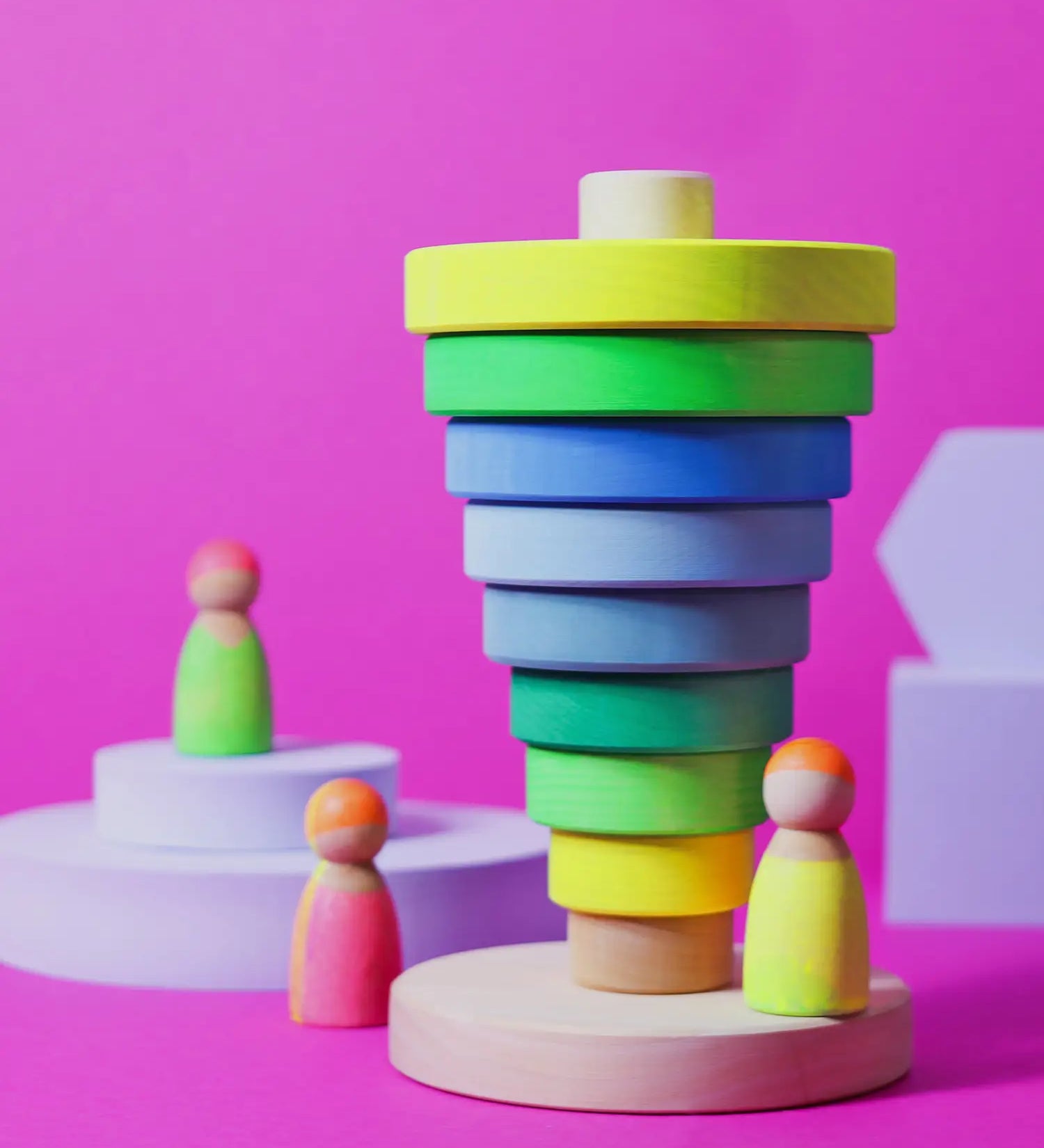 Inverted stack using wooden pieces from the Grimms neon green conical tower standing next to neon peg dolls.