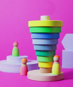 Inverted stack using wooden pieces from the Grimms neon green conical tower standing next to neon peg dolls.