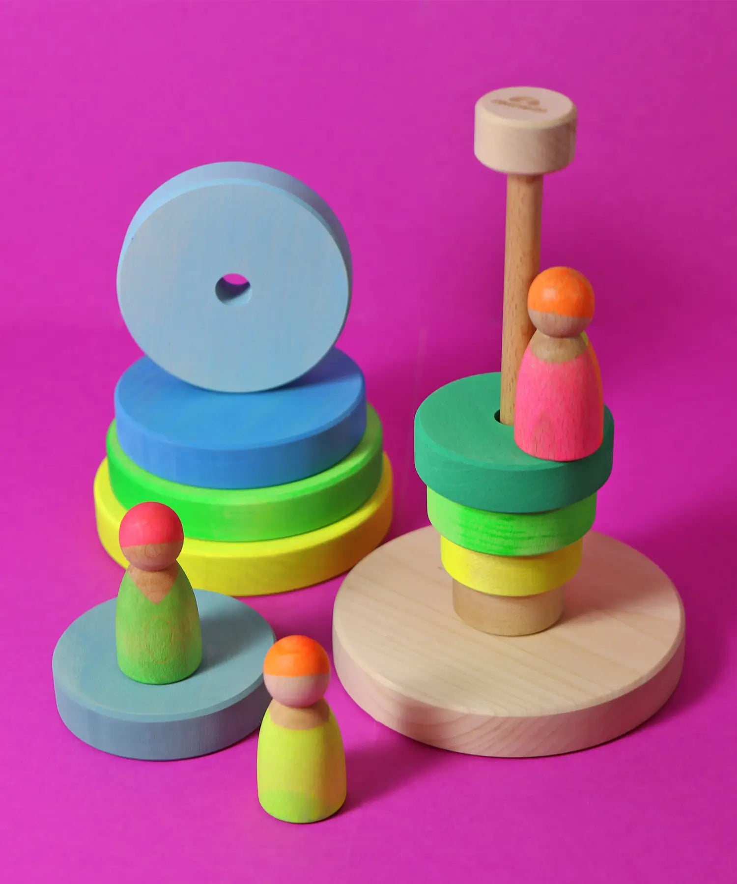 Grimms handcrafted wooden neon green conical tower stacking toy with a natural base with neon peg dolls standing near