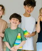 Children holding the large and small Grimms neon green conical stacking tower