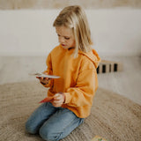 Child holding a pile of Grimms number leaning card showing scale