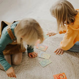 Children playing with the Grimms number learning cards on the floor