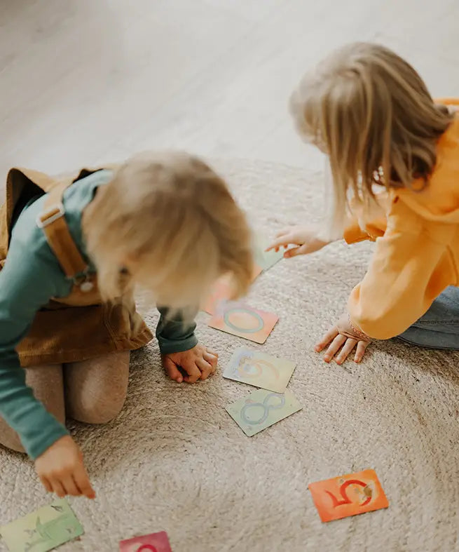 Children playing with the Grimms number learning cards on the floor