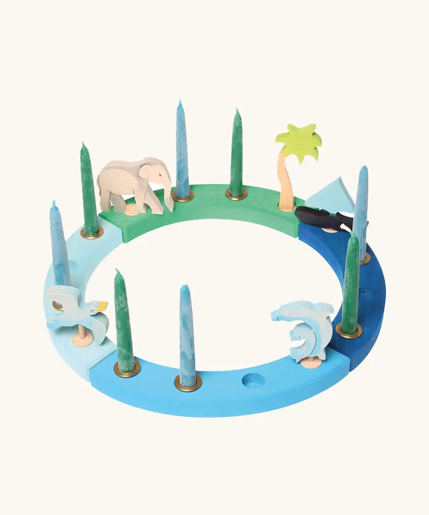 Grimm's handcrafted wooden celebration ring displayinga boat, two dolphins, seagull, elephant and a palm tree decorative figure
