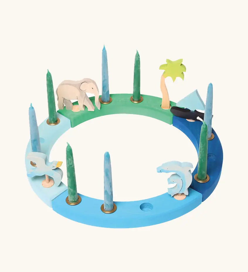 Grimm's handcrafted wooden celebration ring displayinga boat, two dolphins, seagull, elephant and a palm tree decorative figure