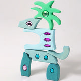 Pieces from the Grimm's orient sparkling building set wooden toy used to create a dinosaur shaped stack.