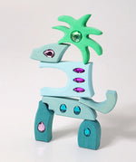 Pieces from the Grimm's orient sparkling building set wooden toy used to create a dinosaur shaped stack.