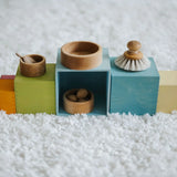 Grimms large pastel building boxes line up with various items on top and inside