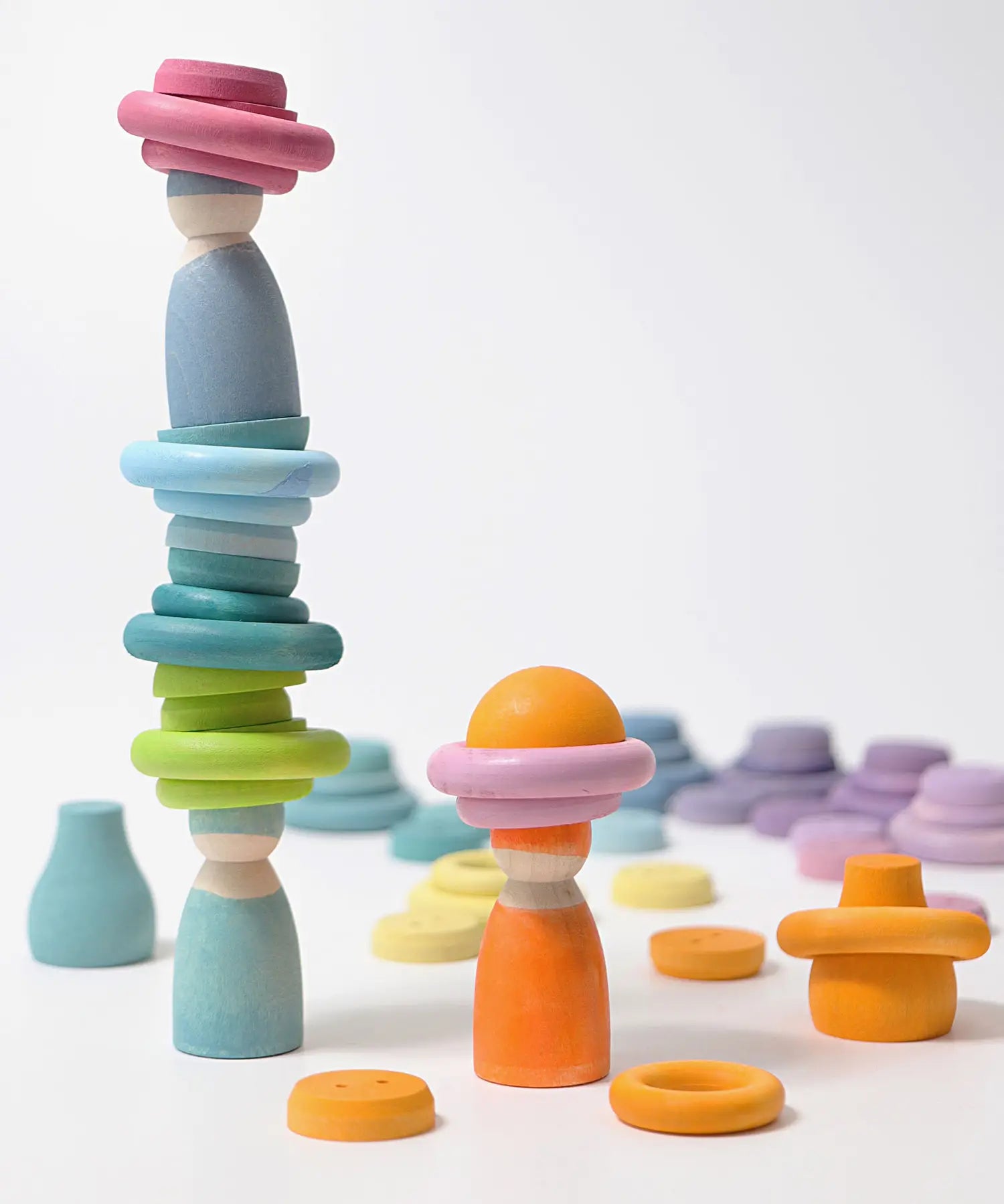 Grimms handcrafted wooden pastel coloured peg dolls with rings and half spheres stacked on top 