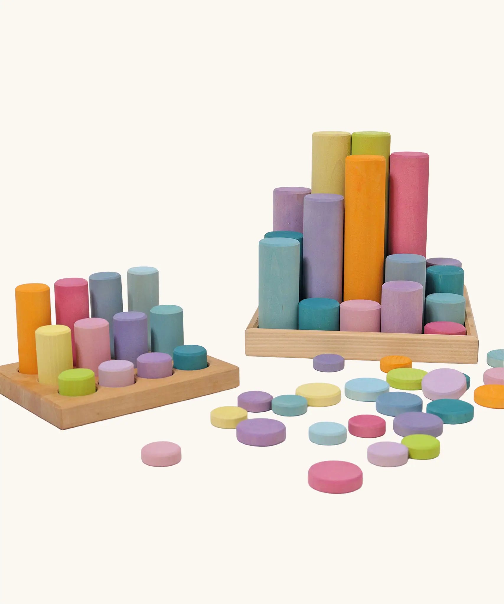 Grimm's large building rollers pastel in a wooden storage tray next to the smaller version of the set.
