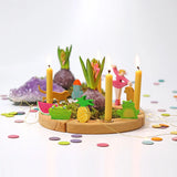 Grimms wooden celebration ring showing decorative figures, candles and pastel confetti dots