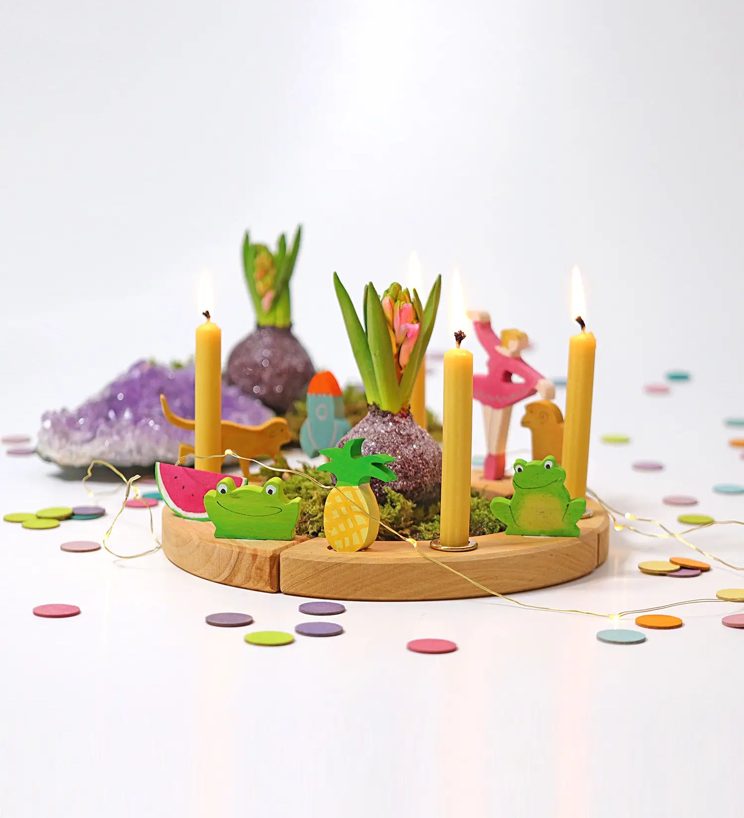 Grimms wooden celebration ring showing decorative figures, candles and pastel confetti dots