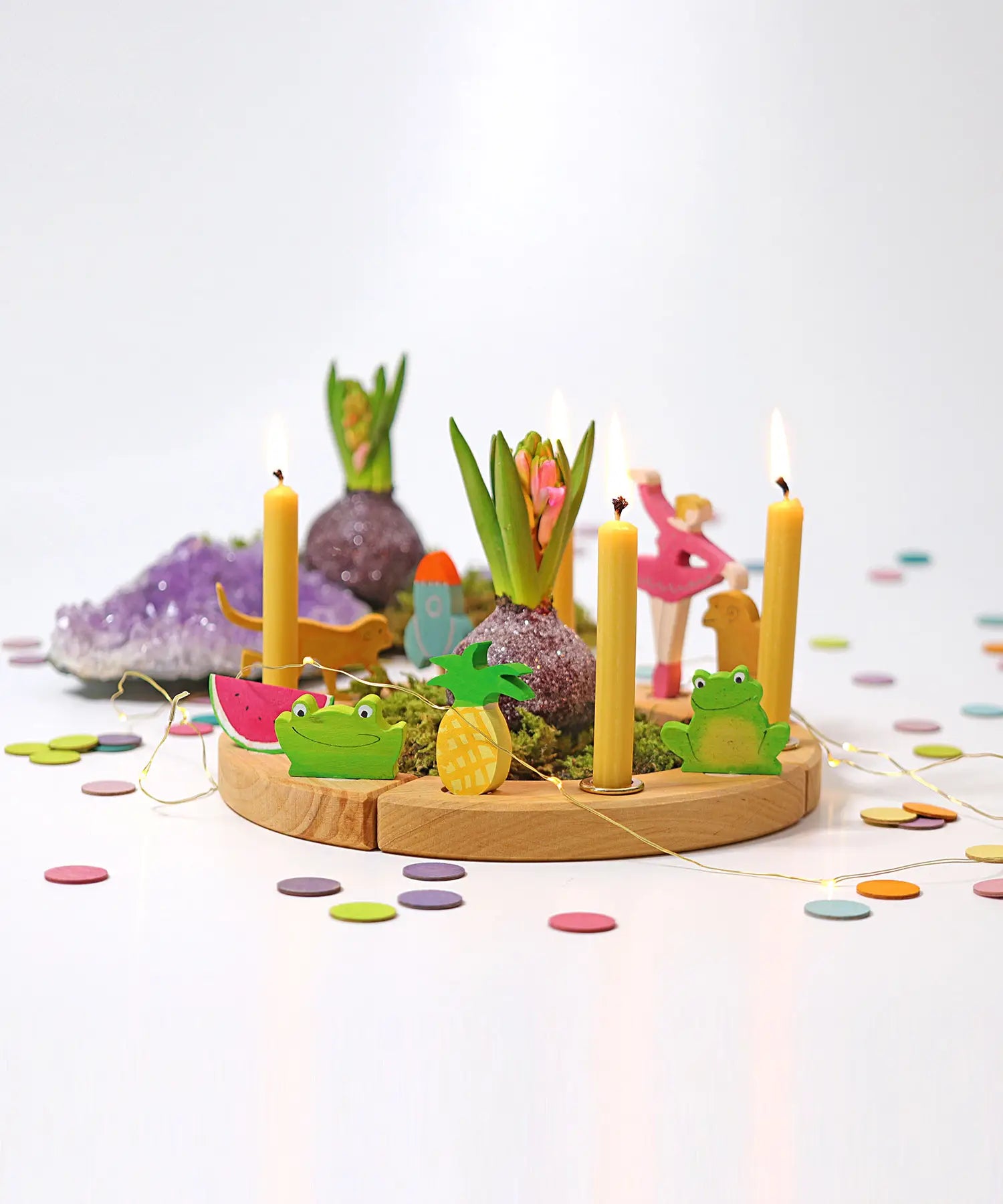 Grimms wooden celebration ring showing decorative figures, candles and pastel confetti dots
