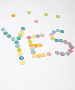 Grimms handcrafted wooden confetti dots in a pastel palette spelling the word YES