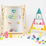 A pastel coloured display using various Grimms wooden pieces and blocks and a Triclimb climbing frame