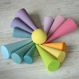 Grimms wooden pastel forest pieces laid flat with a yellow ball in the middle