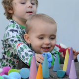 Children playing with the Grimms pastel forest set on a wall with plush dwarf dolls