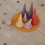 Grimms pastel forest pieces standing on a small plate with matching rings