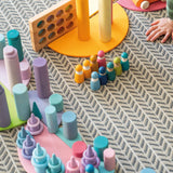 Play setup using various Grimms wooden pastel building blocks and loose pieces