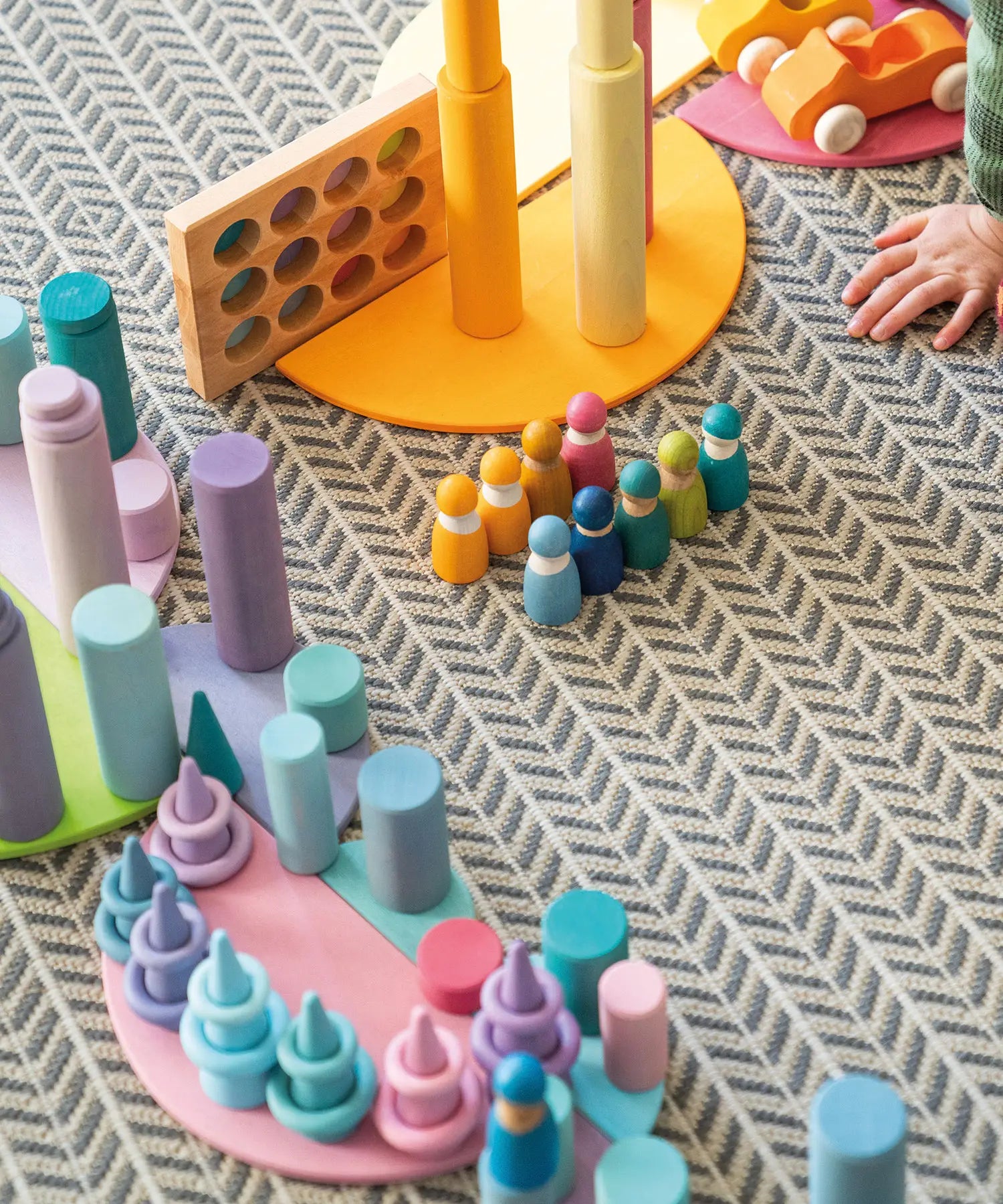 Play setup using various Grimms wooden pastel building blocks and loose pieces