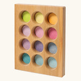 Grimms handcrafted wooden sorting board with 12 round slots in delicate pastel colours, made for sorting games