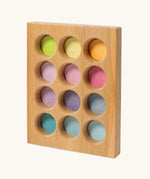 Grimms handcrafted wooden sorting board with 12 round slots in delicate pastel colours, made for sorting games