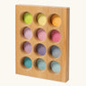 Grimms handcrafted wooden sorting board with 12 round slots in delicate pastel colours, made for sorting games