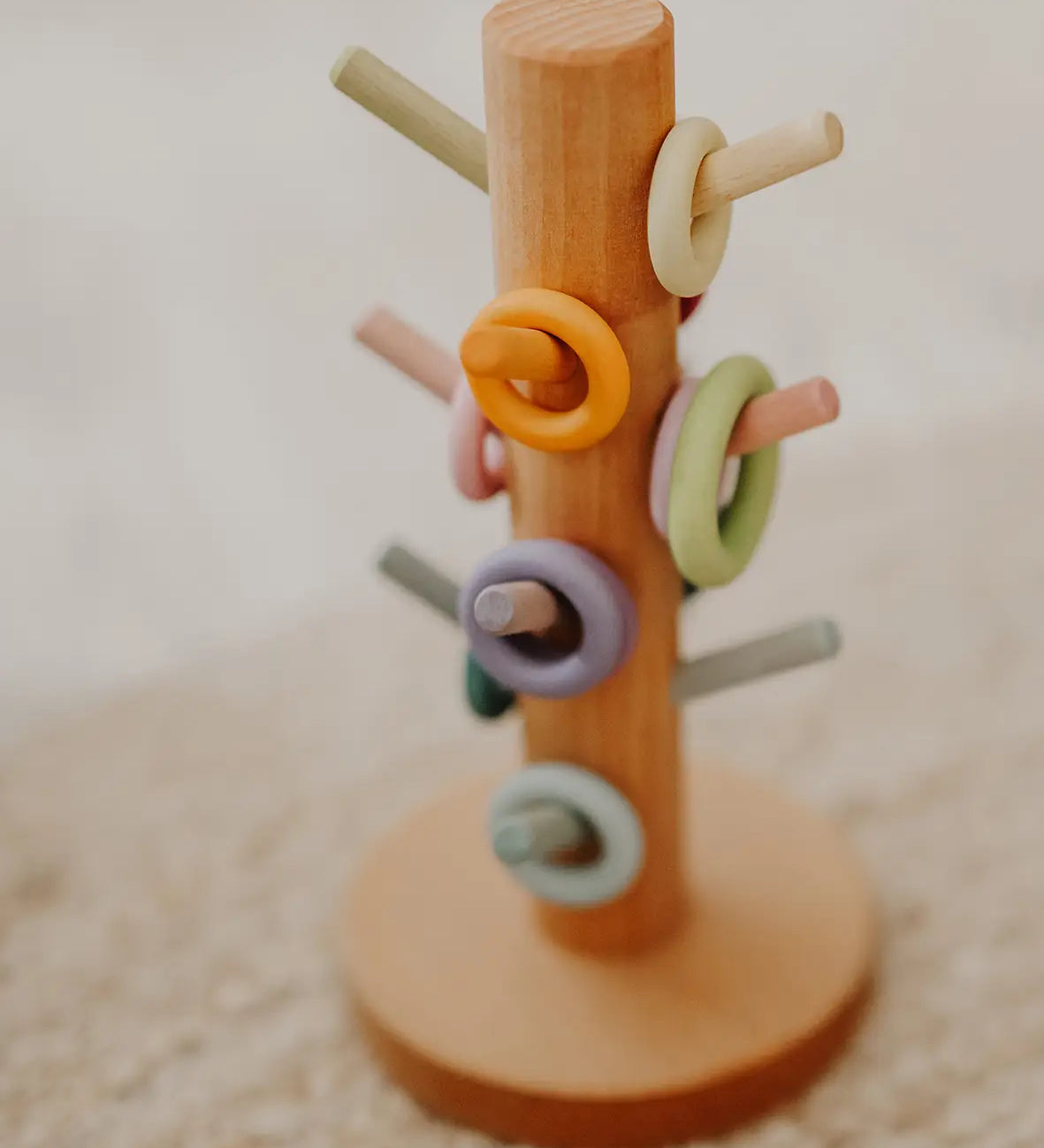 Grimms wooden sorting helper showing wooden ring pieces on matching pastel dowels.