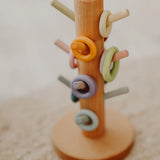 Grimms wooden sorting helper showing wooden ring pieces on matching pastel dowels.