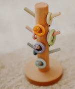 Grimms wooden sorting helper showing wooden ring pieces on matching pastel dowels.