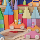 Grimm's pastel stepped roofs wooden building blocks used in a small world play set up with other Grimm's toys and cars.