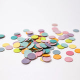 A pile of Grimms handcrafted wooden confetti dots in a pastel palette. 
