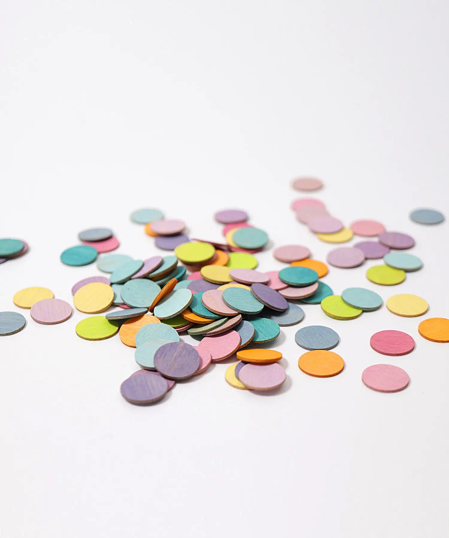 A pile of Grimms handcrafted wooden confetti dots in a pastel palette. 