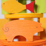 A close up of the Grimms wooden orange pig and yellow fish figure from the counting and story telling set available at Babipur showing the hand painted detail